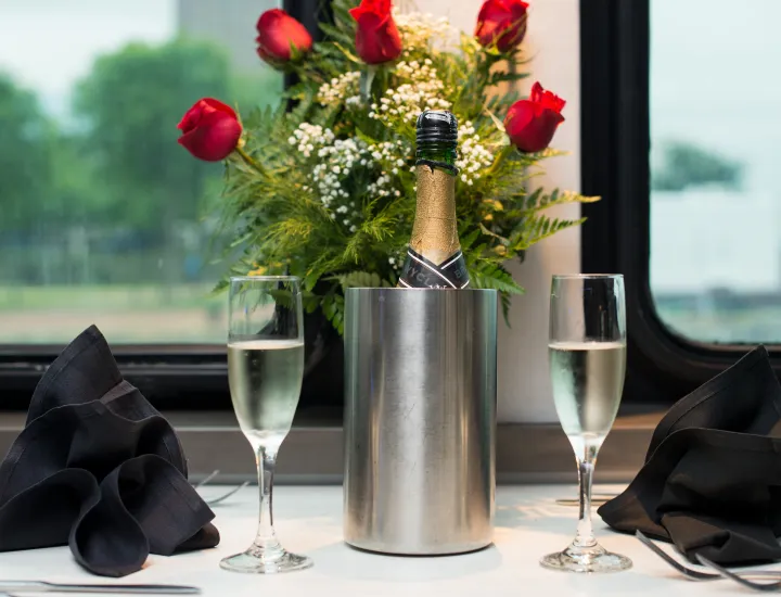 Roses and champagne on table.