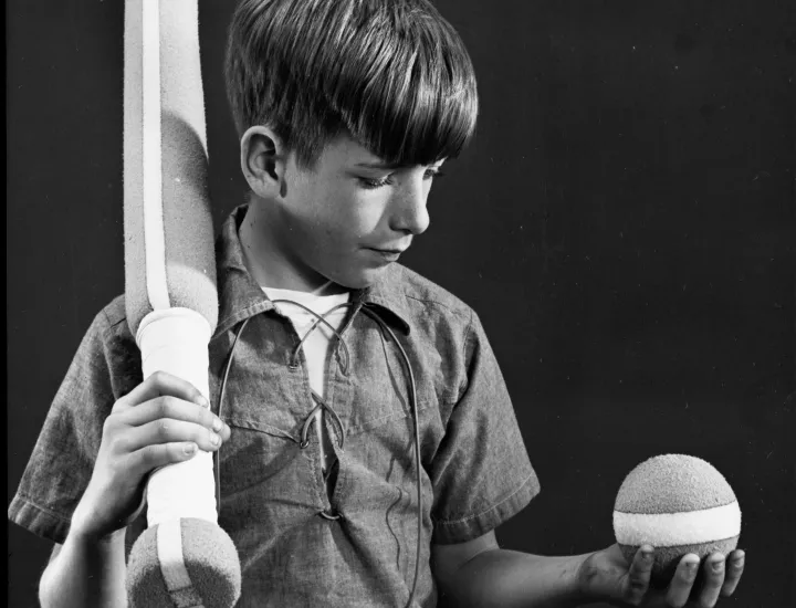 black and white photo of a boy and baseball gear