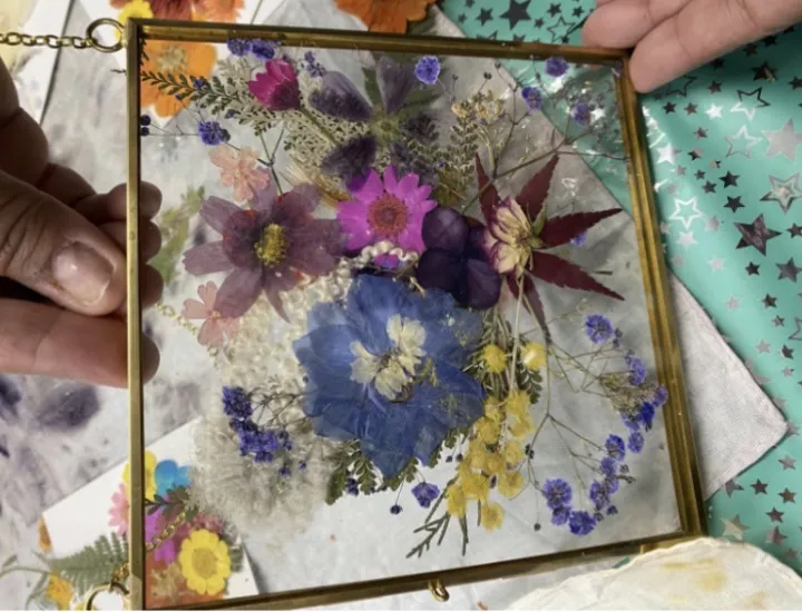 Brass and glass framed pressed flowers by workshop participant