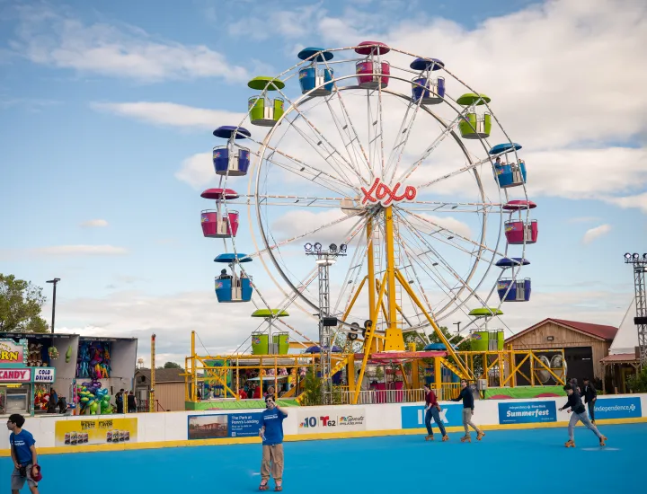 An image of a ferris wheel and roller skaters