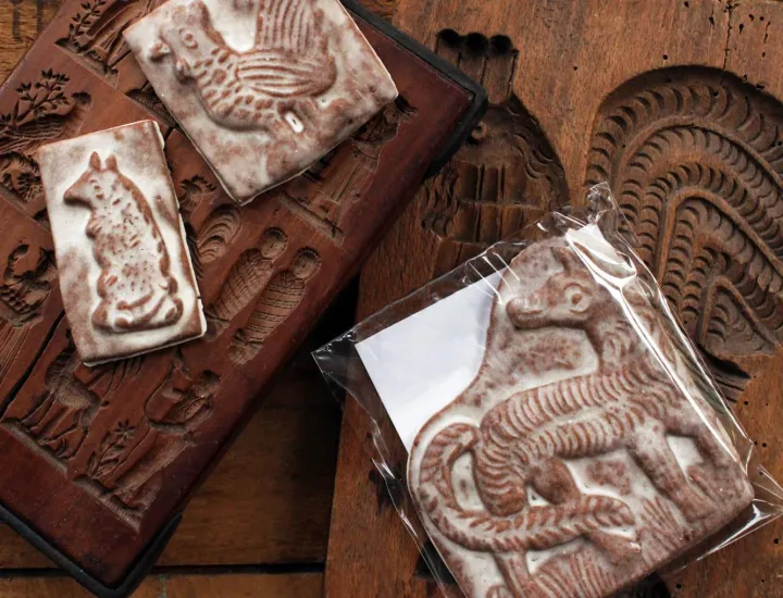 gingerbread cookies in the shape of animals on wooden antique cookie molds