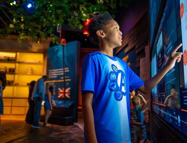 kid in blue shirt uses digital touch screen
